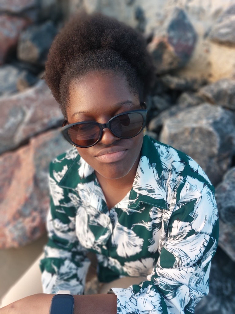 Gigi en chemise verte à motifs, lunettes de soleil